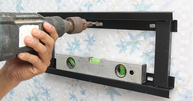 Sử dụng khoan để gắn khung treo lên tường bằng các vít cố định